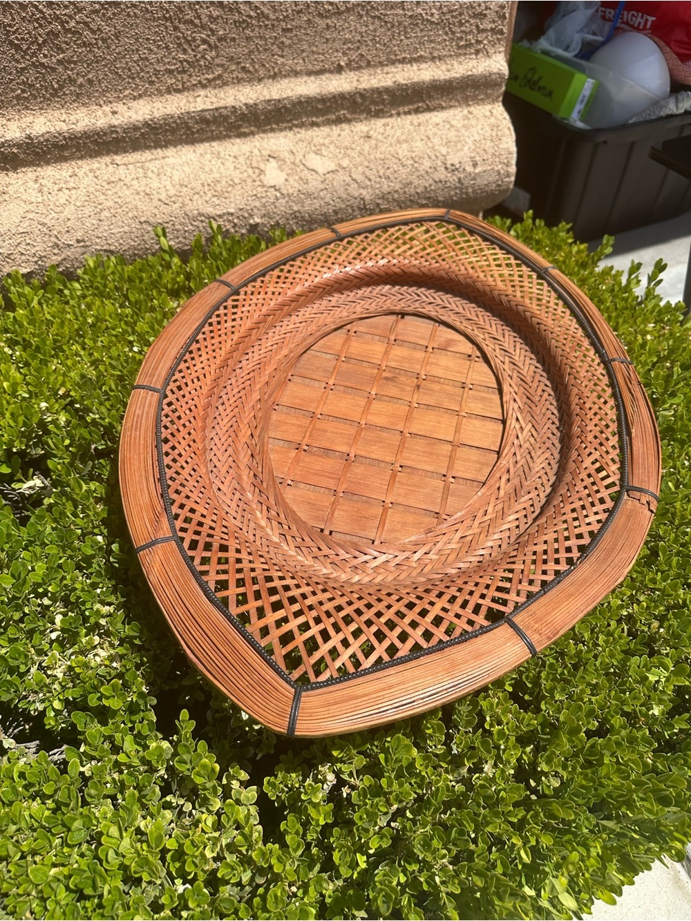 This is a vintage wicker or rattan oval tray often used for wall art